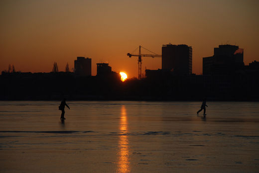 Eislaufen im Sonnenaufgang auf Alstereis