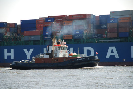 Schlepper neben dem Containerschiff Hyundai